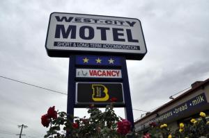 a sign on a pole with flowers on it at West City Motel in Ardeer