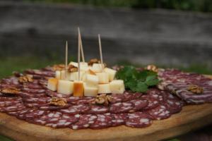 ŽalecにあるGlamping - Ekološka kmetija Kozmanの木板にチーズとナッツを添えたデザート