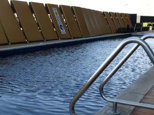 a pool of water with a metal hand railing at ACD Apartments in Melbourne