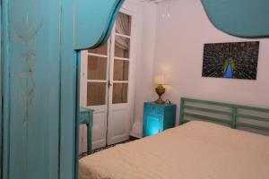 a bedroom with a bed with a blue door and a window at Vintage 1930's flat in the center of Thessaloniki in Thessaloniki