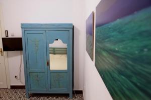 a blue cabinet in a room next to a painting at Vintage 1930's flat in the center of Thessaloniki in Thessaloniki