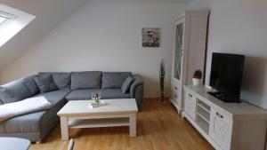 sala de estar con sofá y TV en Ferienwohnung mit Domblick, en Naumburg