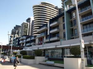 a person walking down a sidewalk in front of a building at ACD Apartments in Melbourne