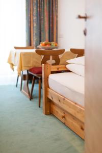 een kamer met 2 bedden en een tafel met een fruitschaal bij Apart Alpenblick in Pfunds