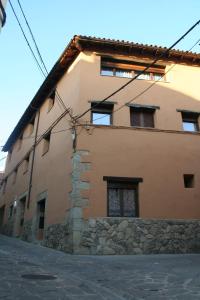 a house with a stone wall and a building at Casa Rural Planeta Vera in Jarandilla de la Vera