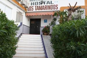 un edificio con escaleras que conducen a un hospital asammammos en Hostal Tamarindos, en Matalascañas