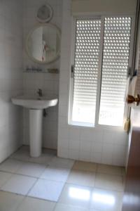 
a bathroom with a sink, toilet and window at Hostal Tamarindos in Matalascañas
