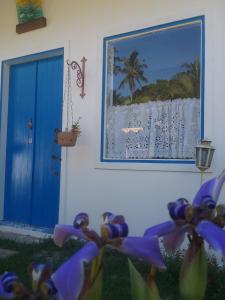 Pousada PraiAmar في سانت أندري: نافذة بباب ازرق وصورة للشاطئ