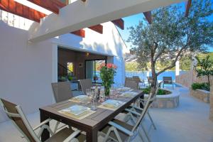 a wooden table and chairs on a patio at Villa Tapenade in Lastovo
