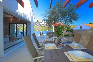 a wooden table with chairs and a vase of flowers at Villa Tapenade in Lastovo