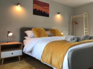 um quarto com uma cama grande e toalhas em The Cothi Bridge Apartments em Carmarthen