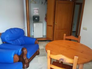 a living room with a blue couch and a table at Hostal Sol Bahía San José in San José