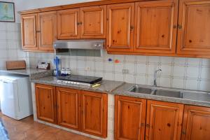 una cocina con armarios de madera y fregadero en Maridea - Via Dragonara, en Ponza