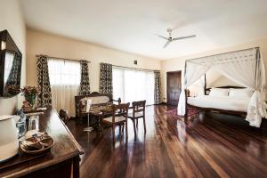 a bedroom with a bed and a table and a dining room at Safari Park Hotel in Nairobi
