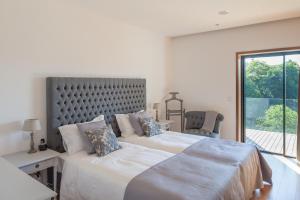 two beds in a white bedroom with a window at Quinta do Fontelo in Vouzela +31 photos