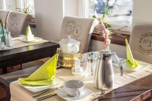 a table in a restaurant with a table set with a tea kettle at Schmid's Landhaus in Werdum