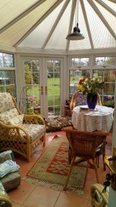 a conservatory with a table and chairs and windows at Mountain Ash in Horncastle