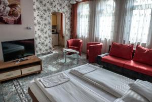 a hotel room with a bed and a couch and a tv at BL Luxus Apartman in Szeged