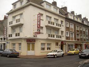 een groot wit gebouw met auto's geparkeerd voor het bij Hôtel Pacific in Calais