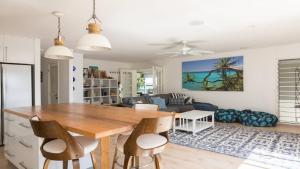 a kitchen and living room with a wooden table and chairs at Mermaid Beach House in Gold Coast