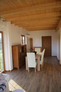 a dining room with a table and white chairs at Lavender Cottage in Charzykowy