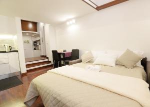 Un dormitorio con una gran cama blanca y una cocina. en Home Alex, en Roma 44 fotos más