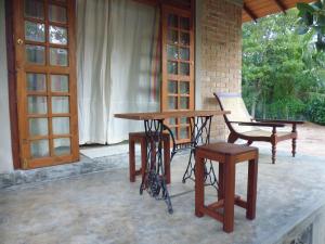 a wooden table and a chair and a table and a door at Lanrich Eco Villas in Mirissa
