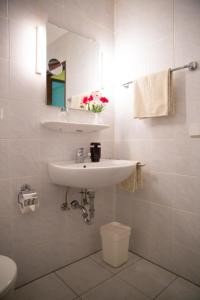 une salle de bain avec un lavabo, des toilettes et un miroir dans l'établissement Hotel Zur Brücke, à Krefeld