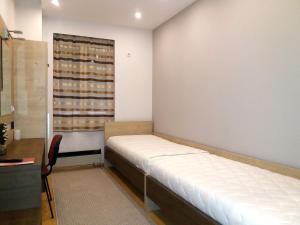 mały pokój z łóżkiem i oknem w obiekcie Apartment Millas w Niszu