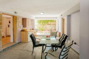 a dining room with a table and chairs and a kitchen at Lemonia Home in Sirílion