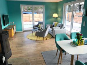 プレローにあるFerienhaus Bartiの緑の壁のリビングルーム(ソファ、椅子付)