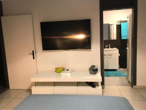 a room with a white table with a tv on the wall at Tampok lodge in Cayenne