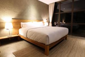 a bedroom with a large bed and two lamps at Inchantreedoopool in Kanchanaburi City