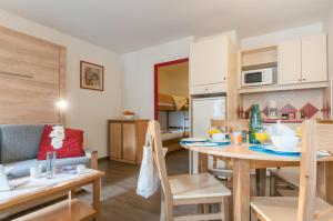 a kitchen and living room with a table and chairs at Résidence Pierre & Vacances La Rivière in Chamonix