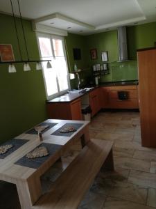 cocina con paredes verdes y mesa de madera en Home sweet Home, en Homburg