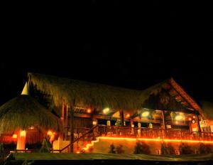 a building with a straw roof with lights on it at Masamayor's Beach House and Resort in Camotes Islands