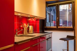 a red kitchen with a sink and a red wall at Schirle in Zermatt