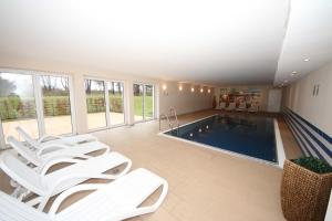 a swimming pool with white lounge chairs and a swimming pool at Haus Meeresblick - 2.11 Sonnendeck in Baabe