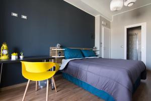 una camera con letto, scrivania e sedia gialla di Turiddu B&B a Catania