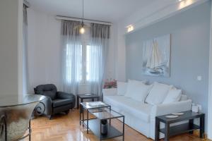 a living room with a white couch and a chair at Apartment in Glyfada Center in Athens