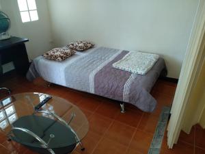 Dormitorio pequeño con cama y mesa de cristal en Right on the beach house en Taling Ngam Beach