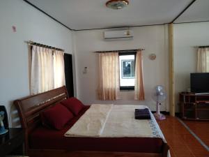 1 dormitorio con cama, sofá y ventana en Right on the beach house en Taling Ngam Beach