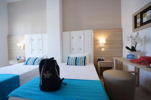 a backpack sitting on a bed in a hotel room at Nicolaus Prime Il Gabbiano Hotel in Pulsano