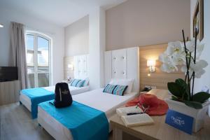 una camera d'albergo con due letti e un tavolo di Nicolaus Prime Il Gabbiano Hotel a Pulsano