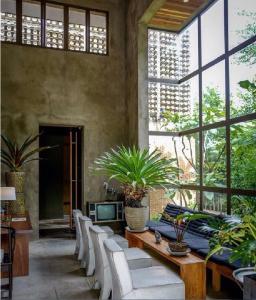 a patio with a table and chairs and a tv at Inchantreedoopool in Kanchanaburi City