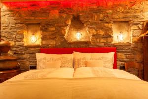 una camera da letto con un grande letto e un muro in pietra di Schnapskeller a Zermatt