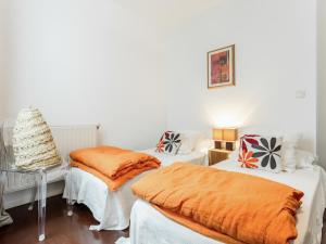 een kamer met 2 bedden en oranje dekens bij Welkeys Apartment - Sainte in Marseille