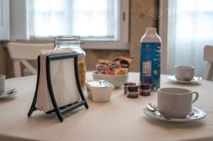a table with a picture frame and cups on it at Oporto Center Clean & Cozy Apt 3 in Porto +8 photos