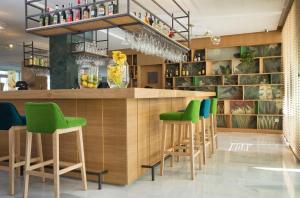 - un bar avec tabourets de bar vert dans un restaurant dans l'établissement JS Alcudi-Mar, à Playa de Muro