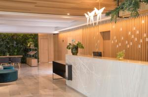an office lobby with a reception counter and plants at JS Alcudi-Mar in Playa de Muro